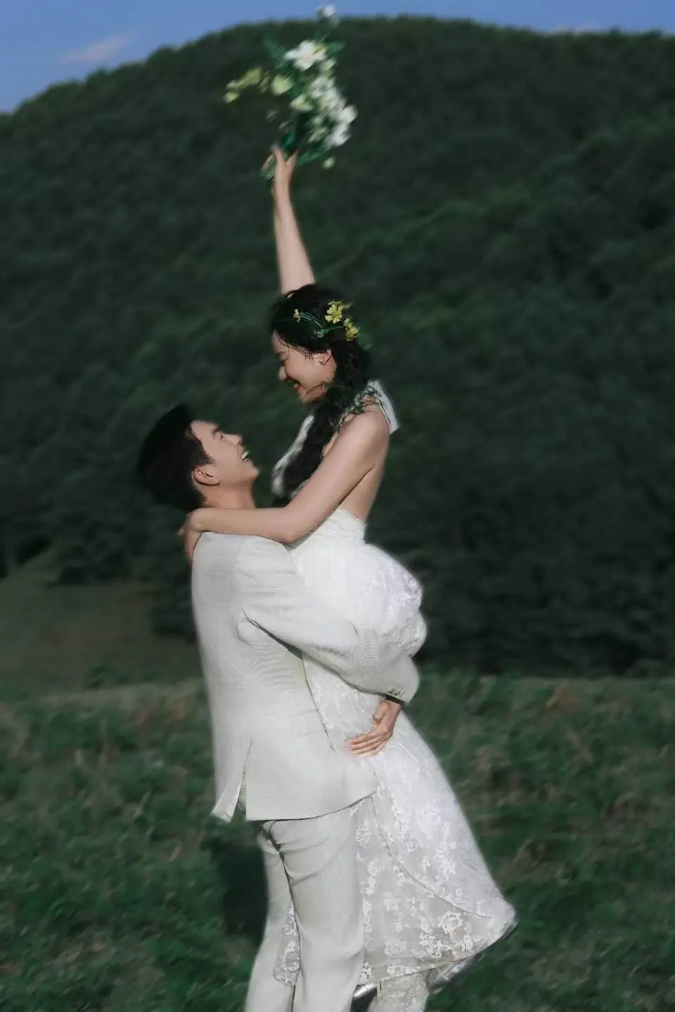 新人在草地上相互依靠的婚纱照